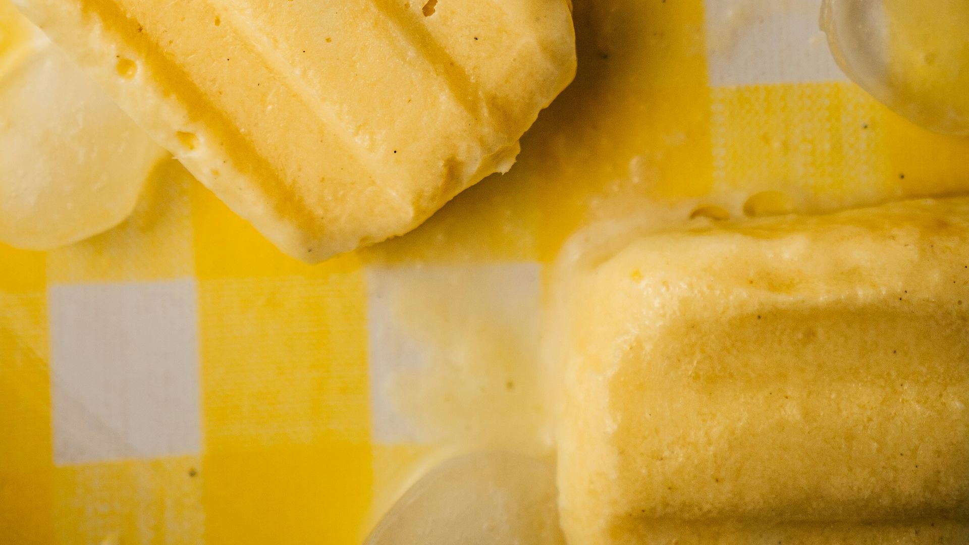 a yellow and white checkered table cloth with ice cream and lemon slices