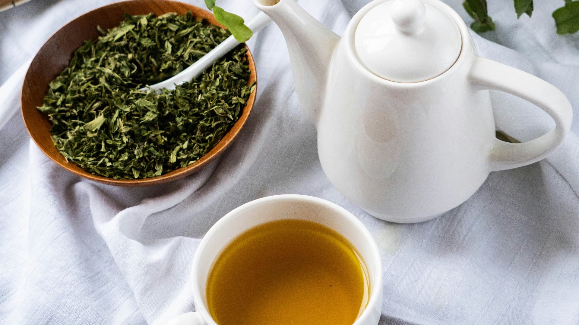 a cup of tea next to a bowl of tea and a book