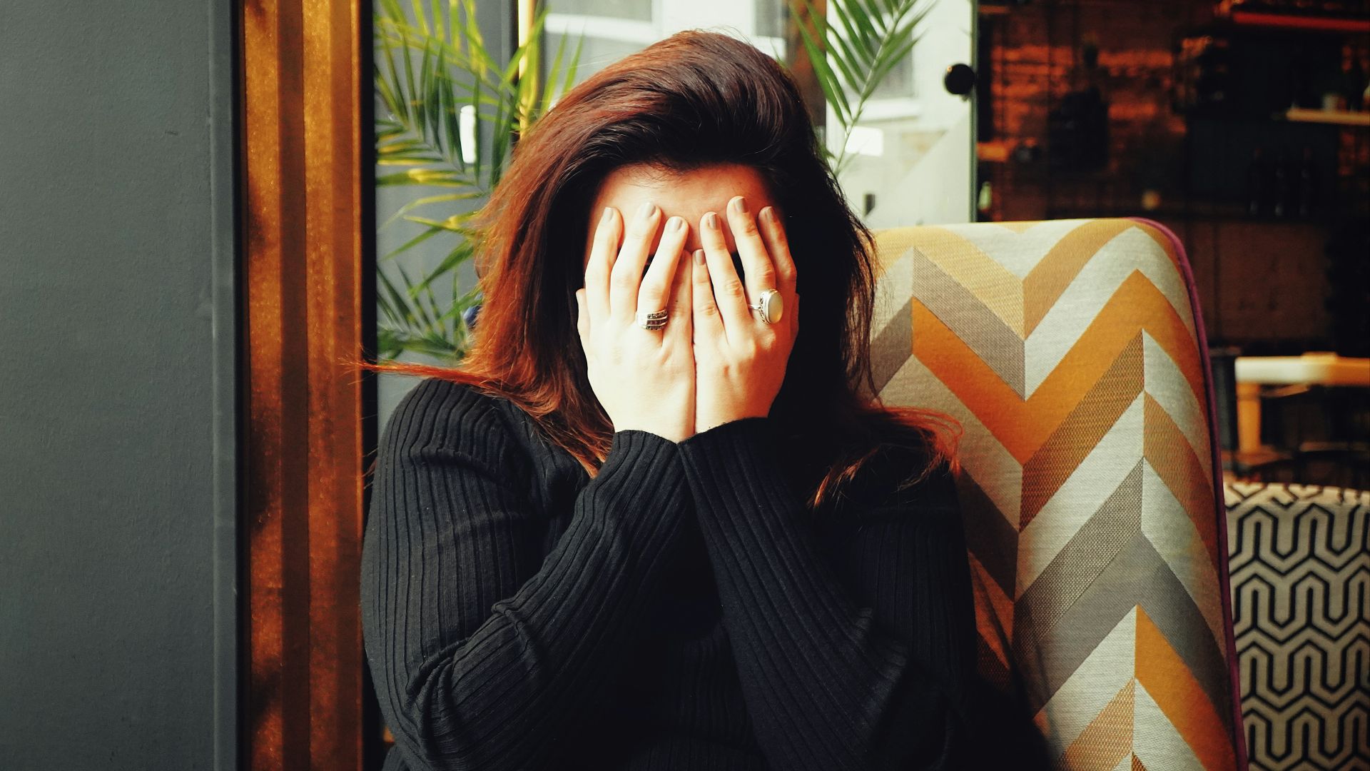 woman in black long sleeve shirt covering her face