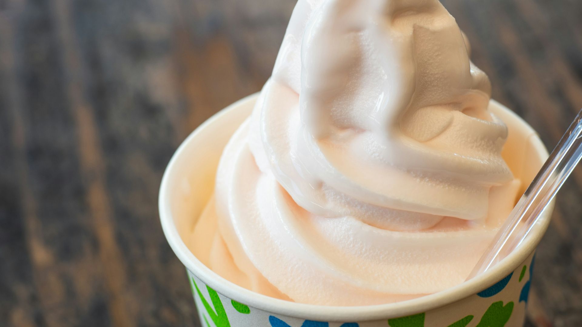 A cup filled with whipped cream on top of a wooden table