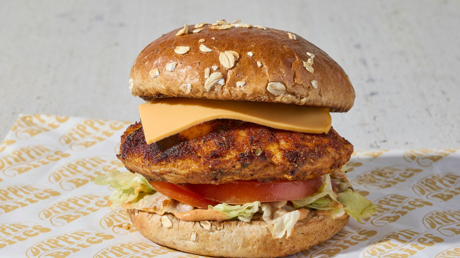 a chicken sandwich with lettuce, tomato, and cheese