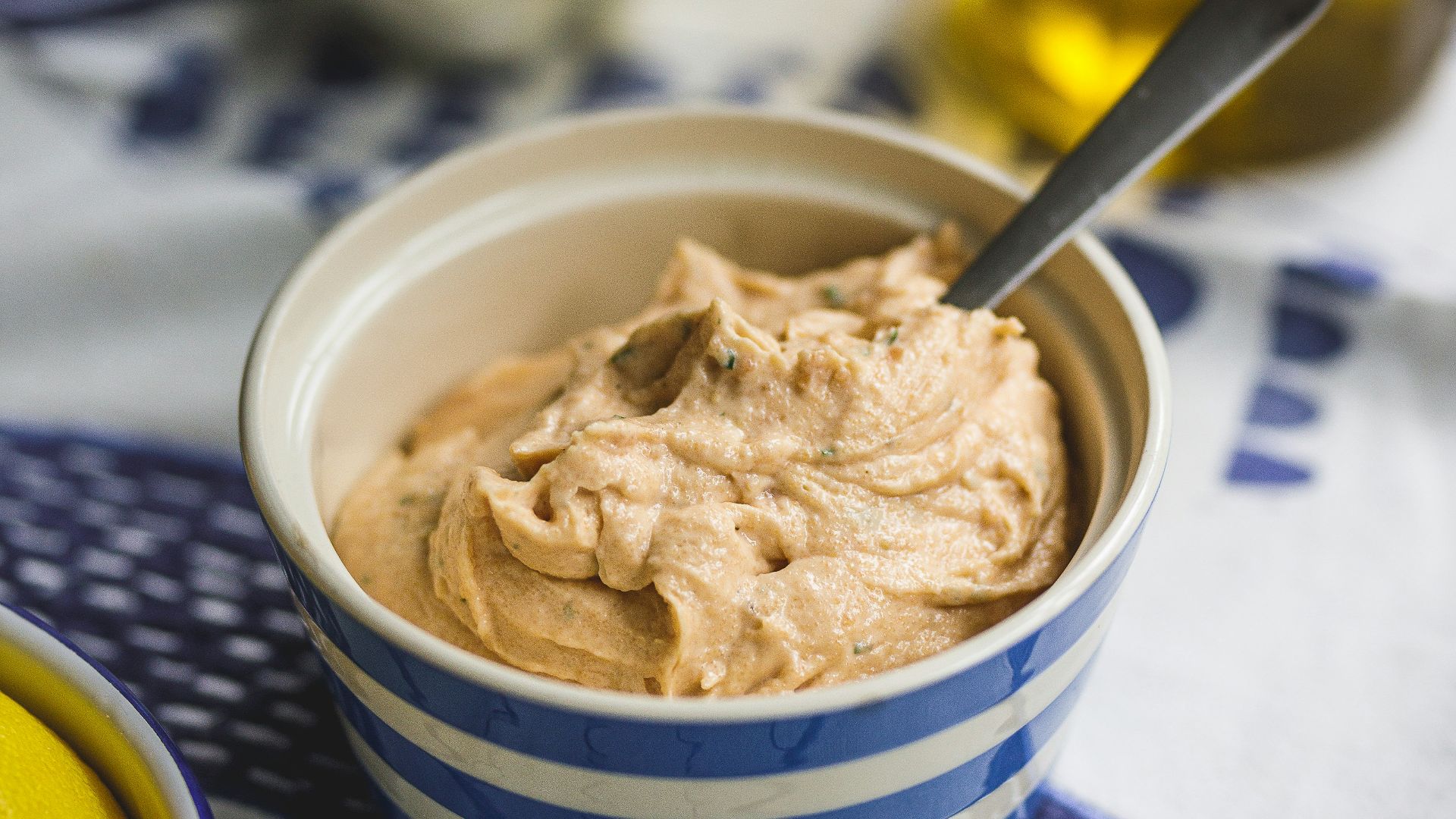 a bowl of hummus next to a bowl of lemons