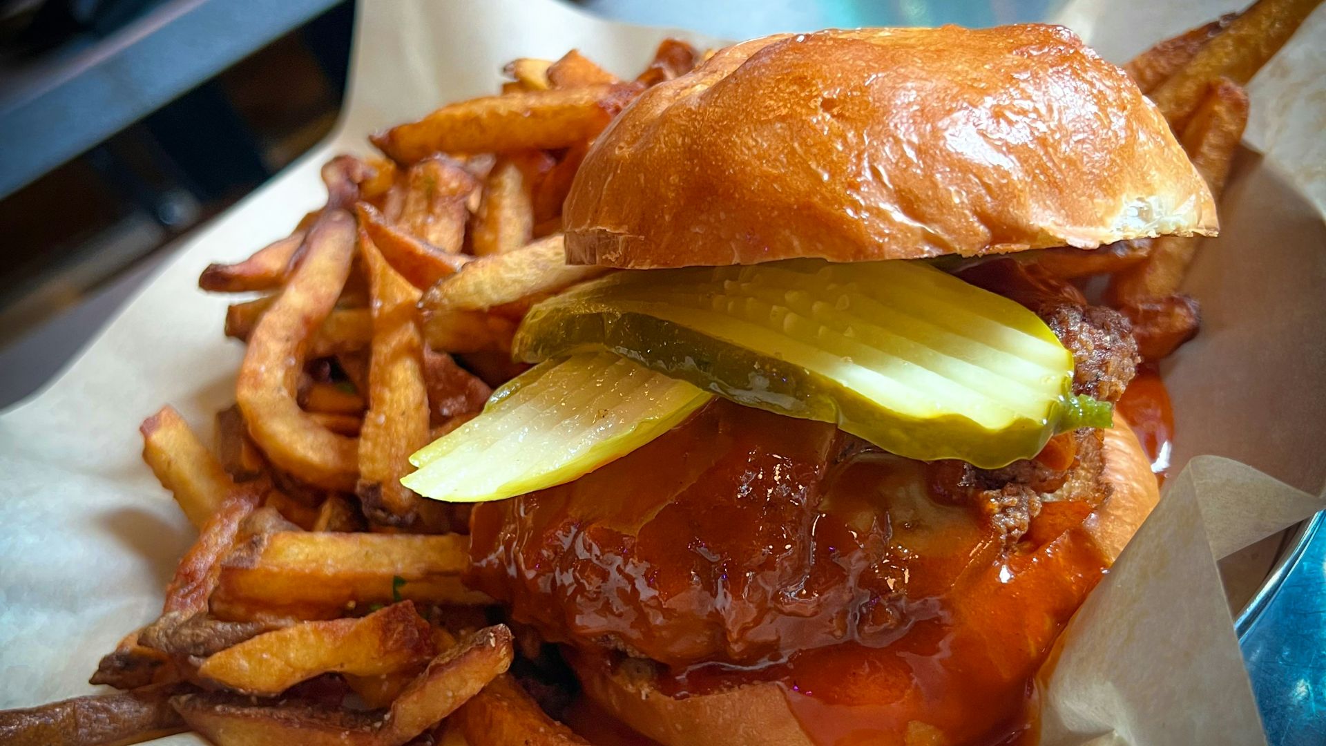 a hamburger with pickles and onions on a roll