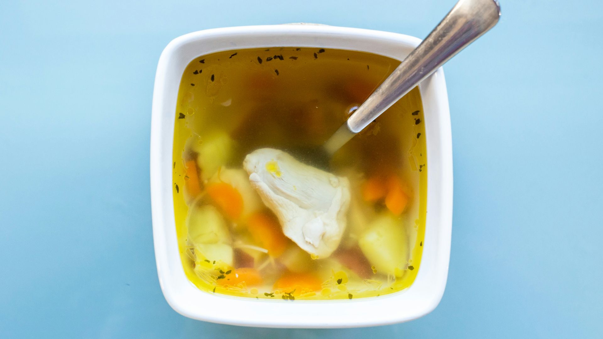 soup with sliced lemon in white ceramic bowl