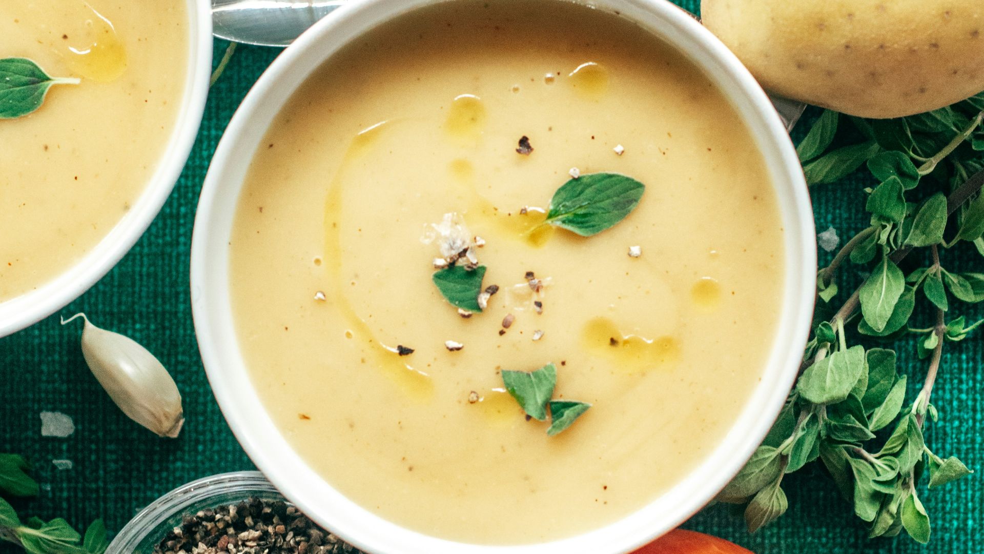 three bowls of soup on a green cloth
