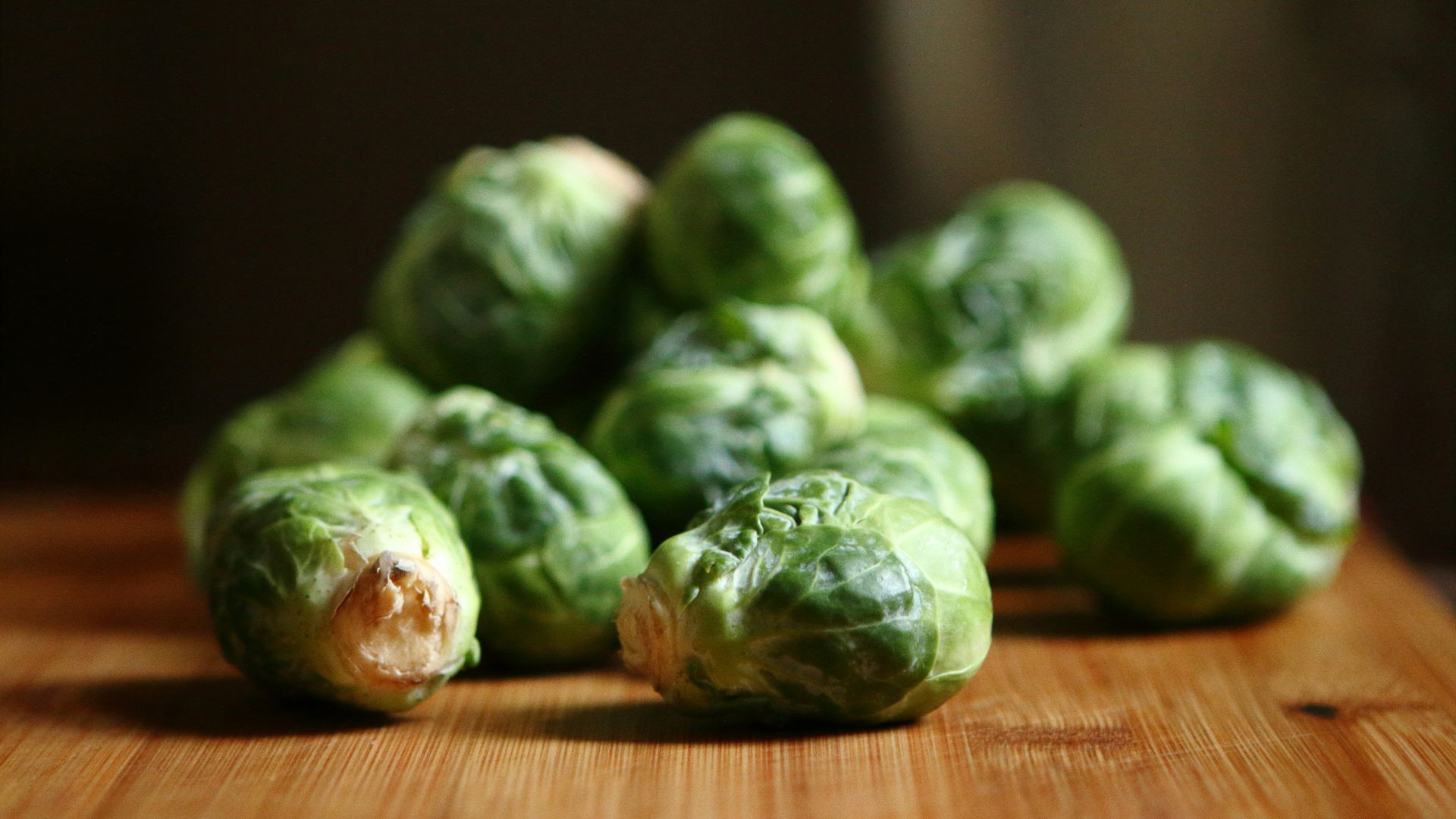 shallow depth of fields photography of green vegetable on brown wooden panel