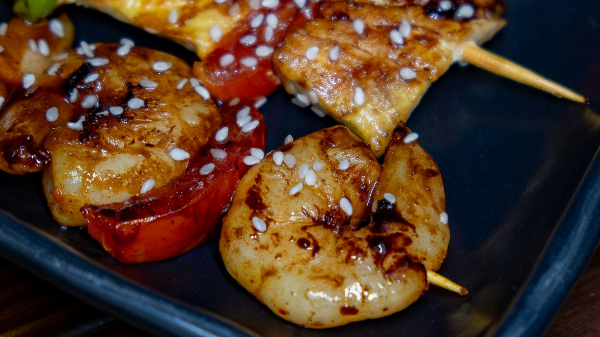 A black plate topped with meat and veggies