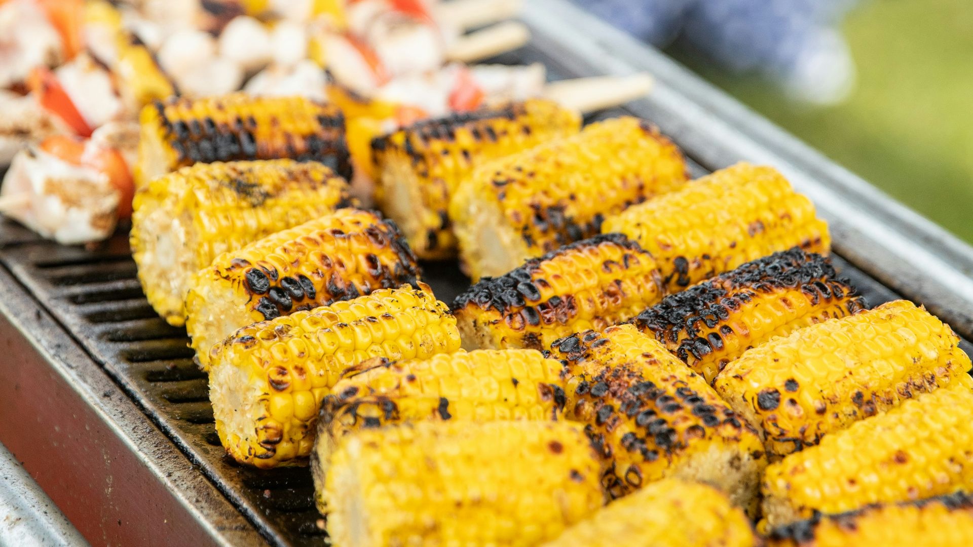 corn on the cob being cooked on a grill