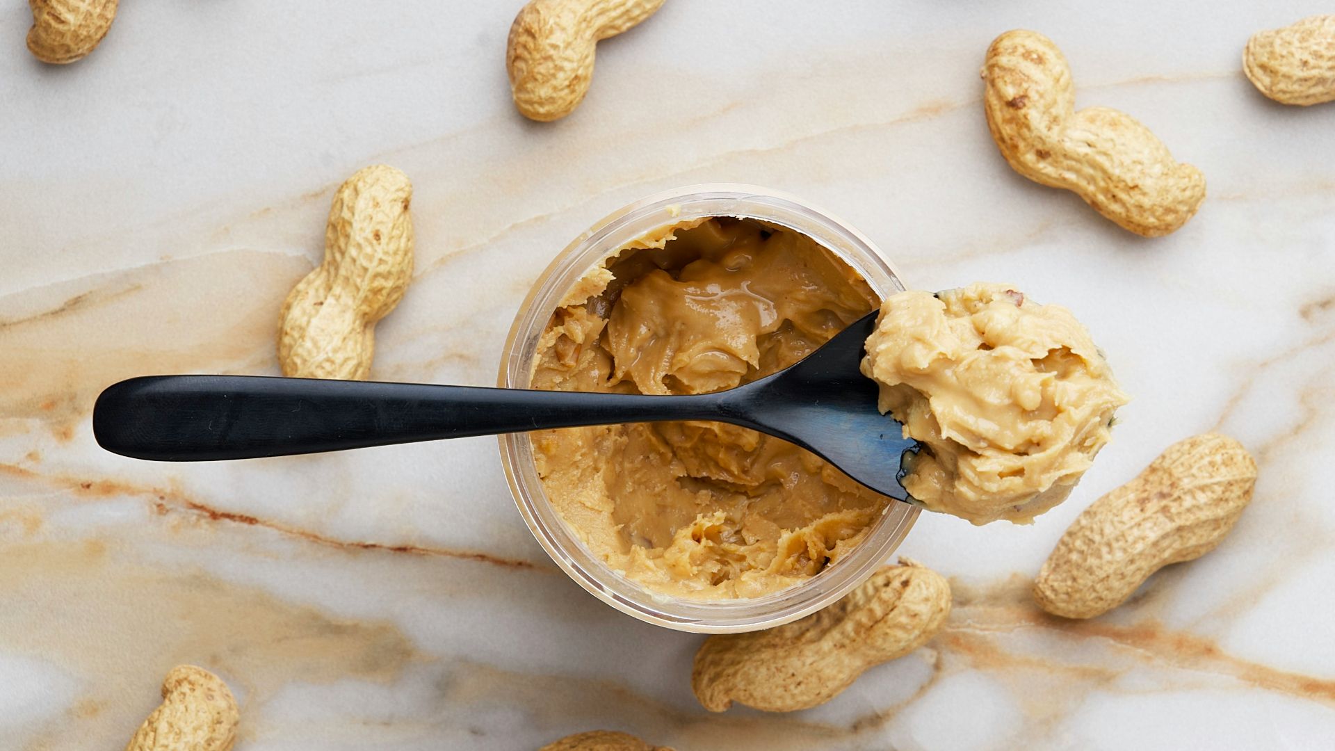 peanut butter with black spoon