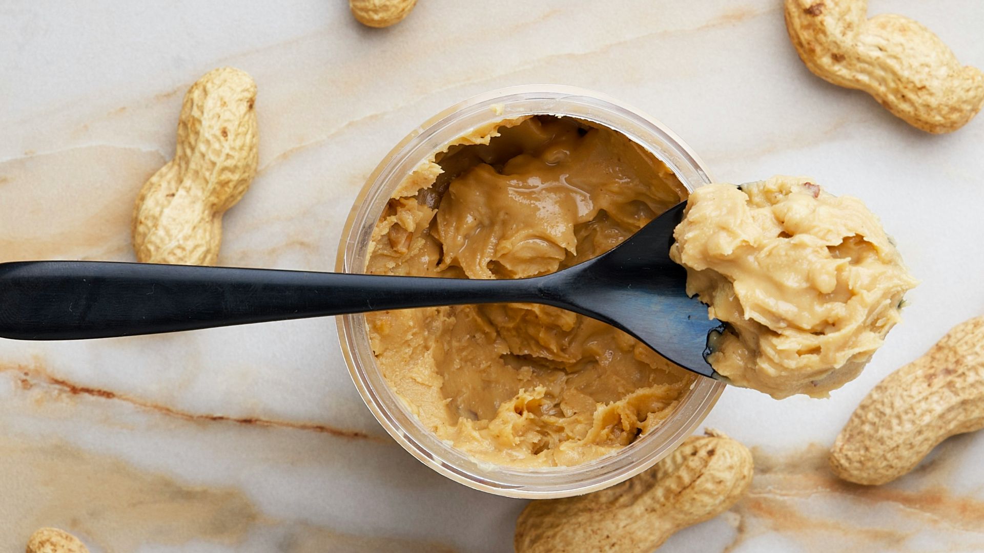 peanut butter with black spoon