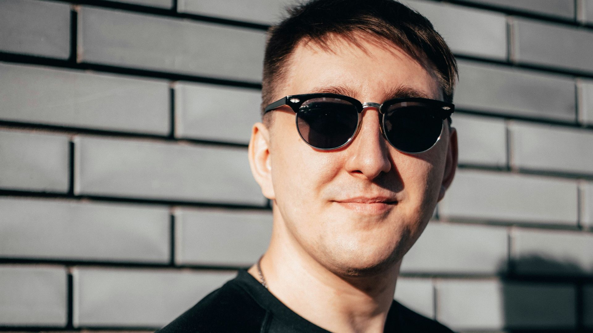 man in black crew neck shirt wearing black sunglasses