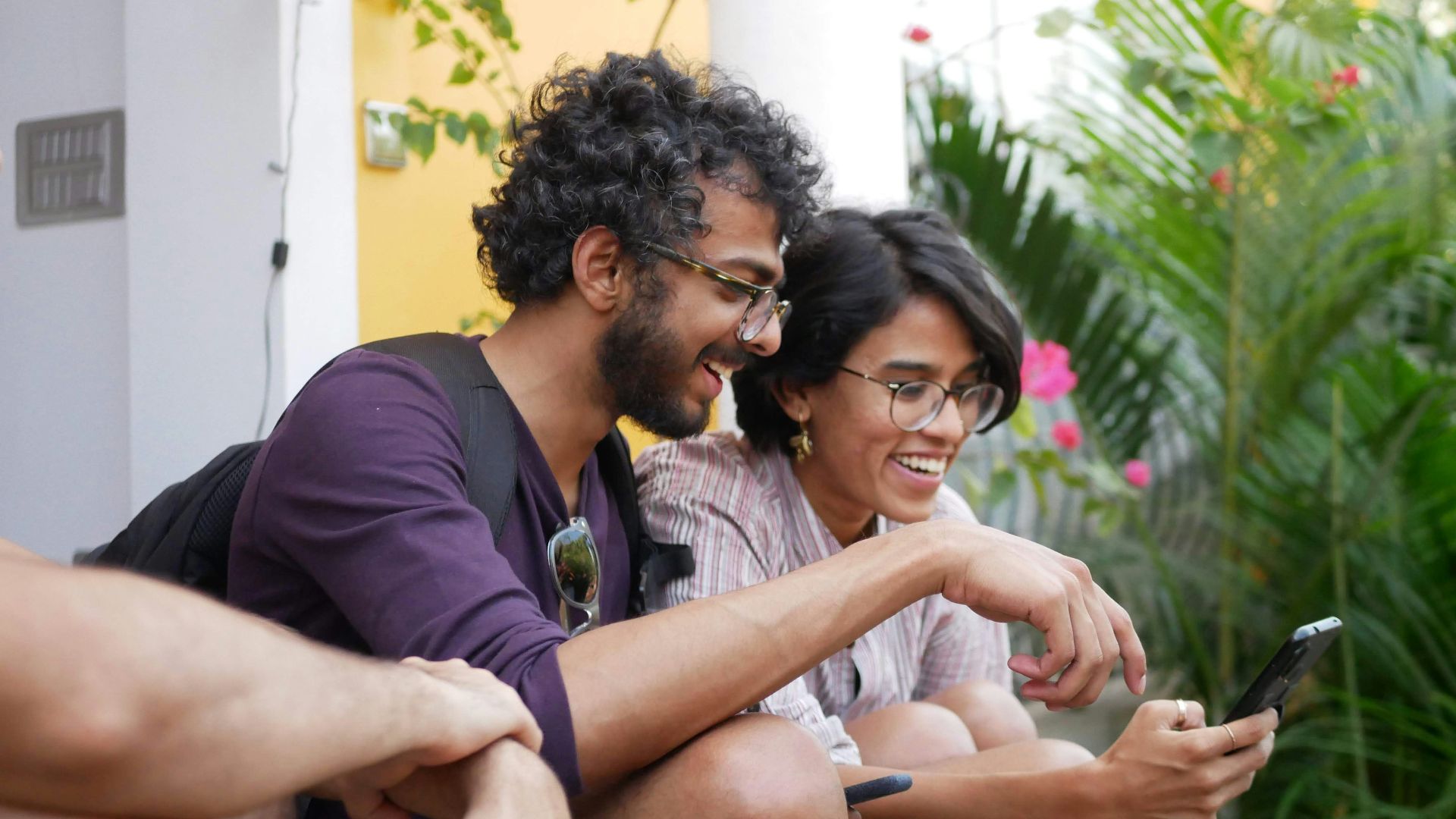 man in black polo shirt sitting beside woman in purple shirt