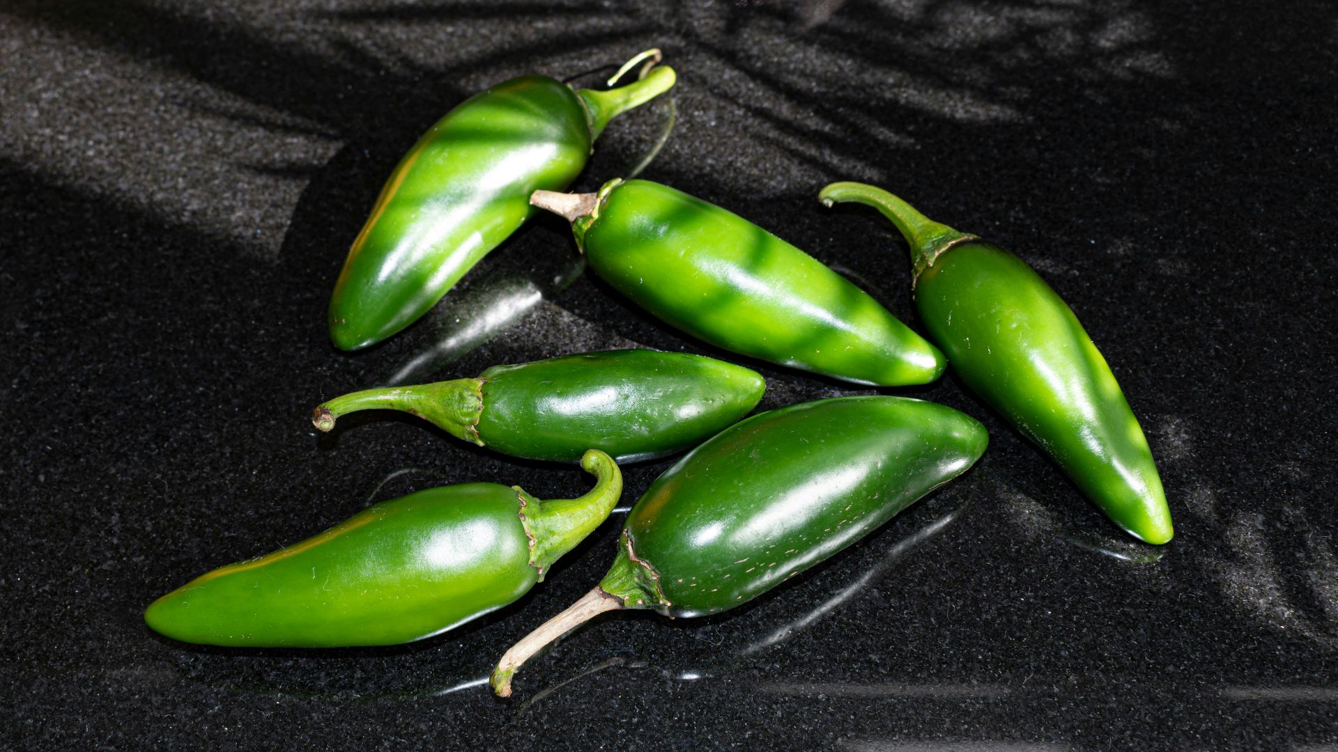 a group of green peppers sitting on top of a counter