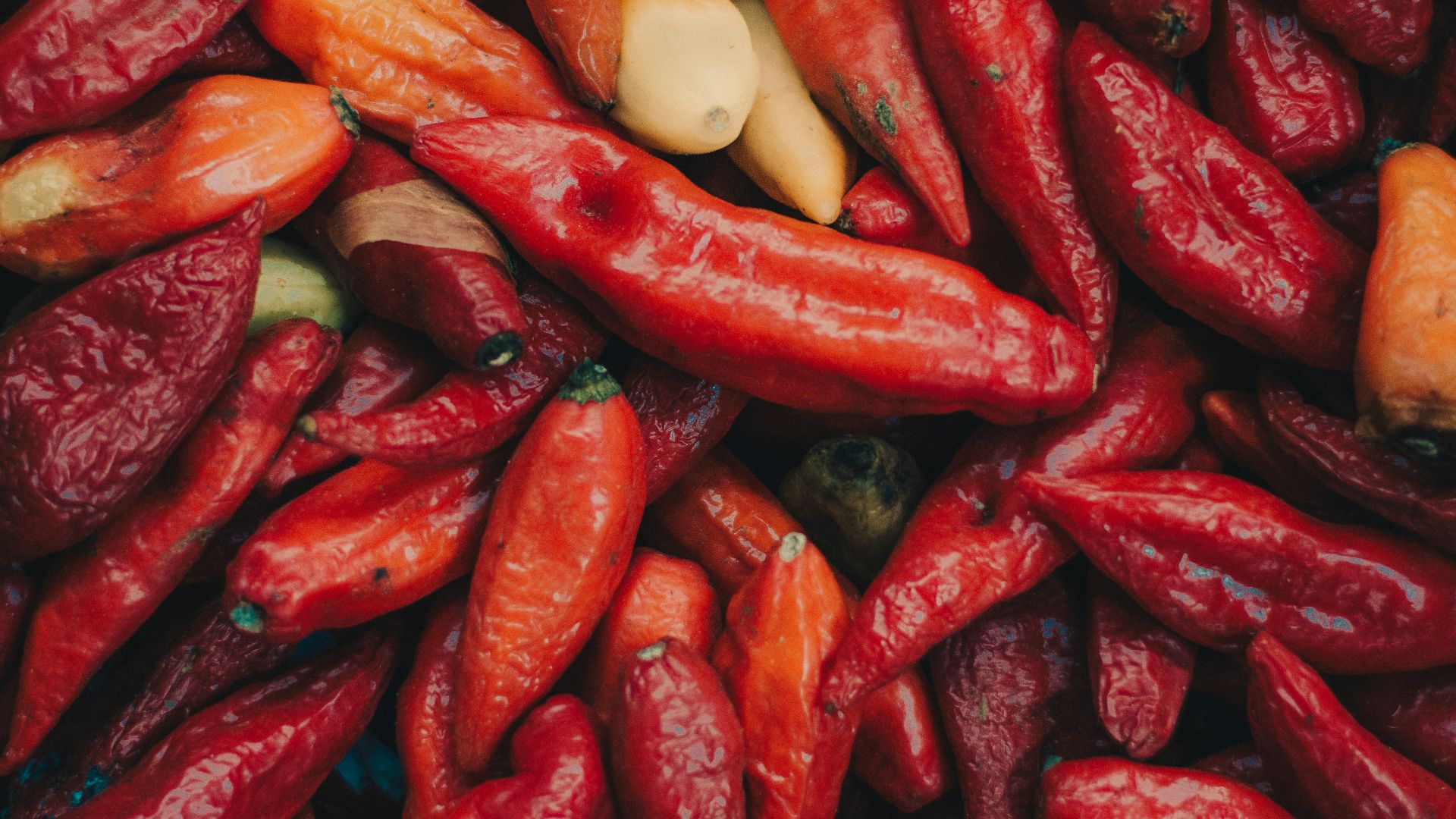a pile of red peppers and other vegetables