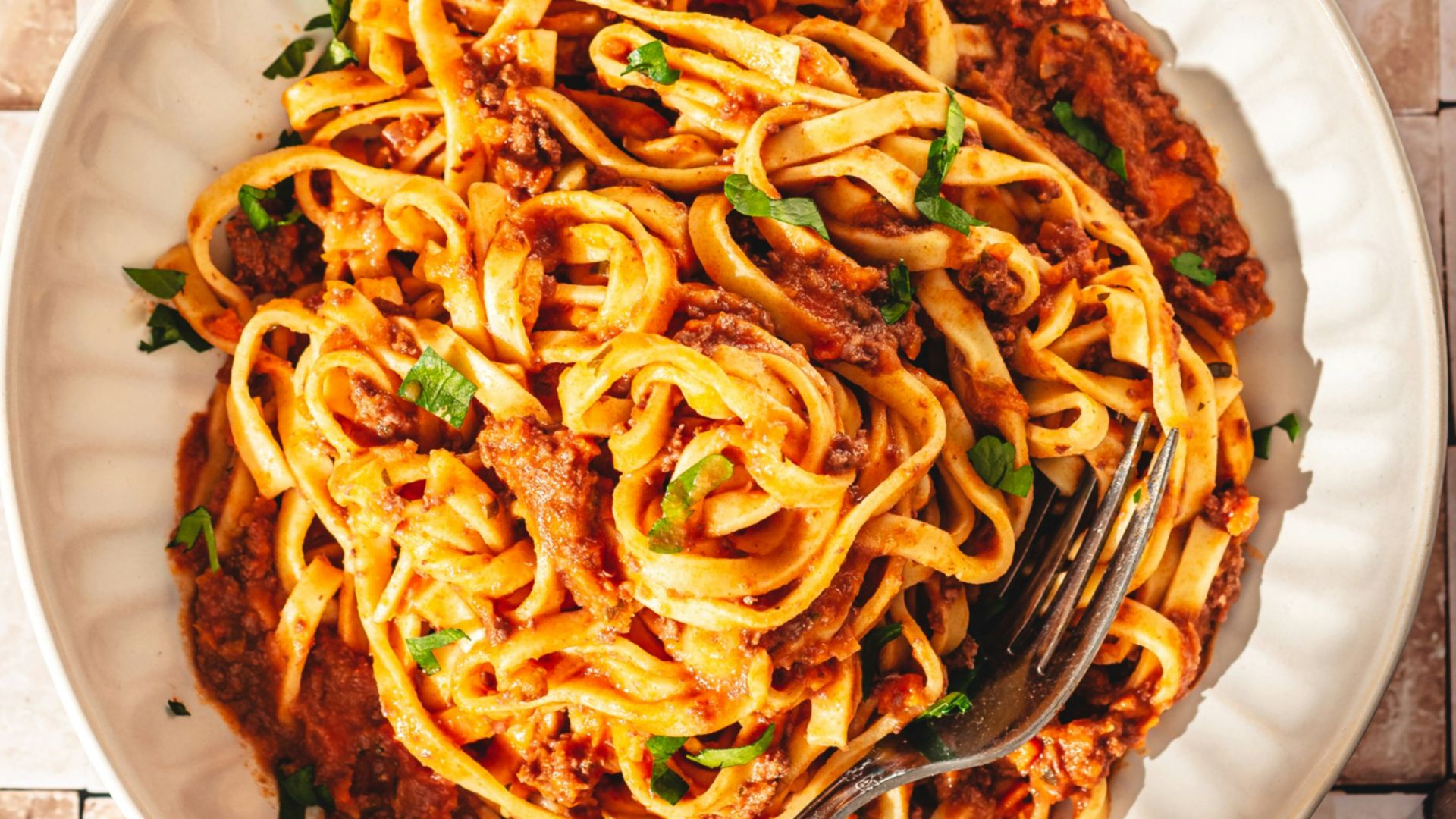 a plate of spaghetti with sauce and bread on a table