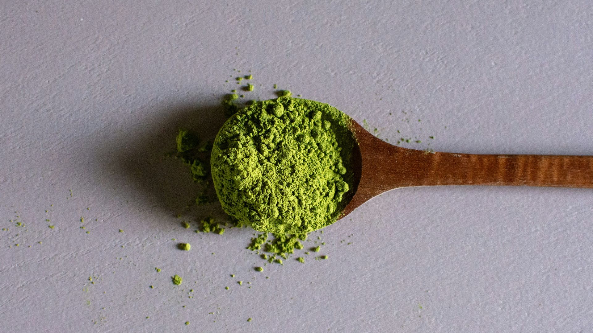 a wooden spoon filled with green powder