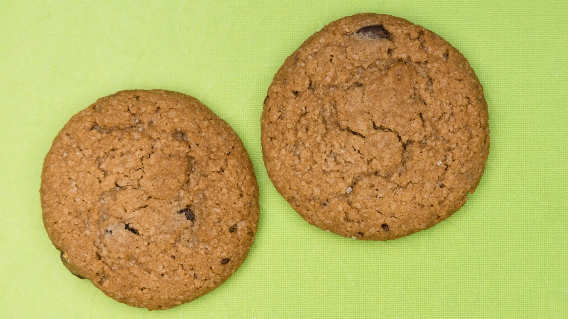 two brown cookies on green surface