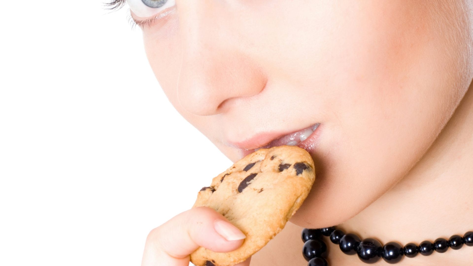 A woman with a cookie in her mouth