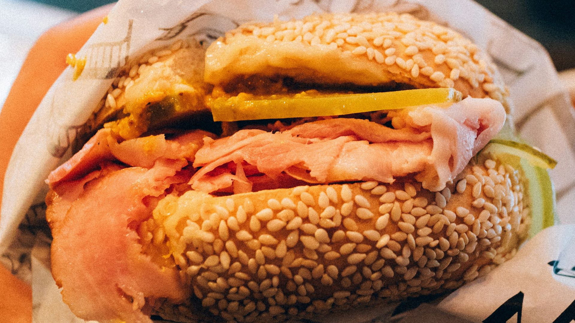 a person holding a sandwich in their hand