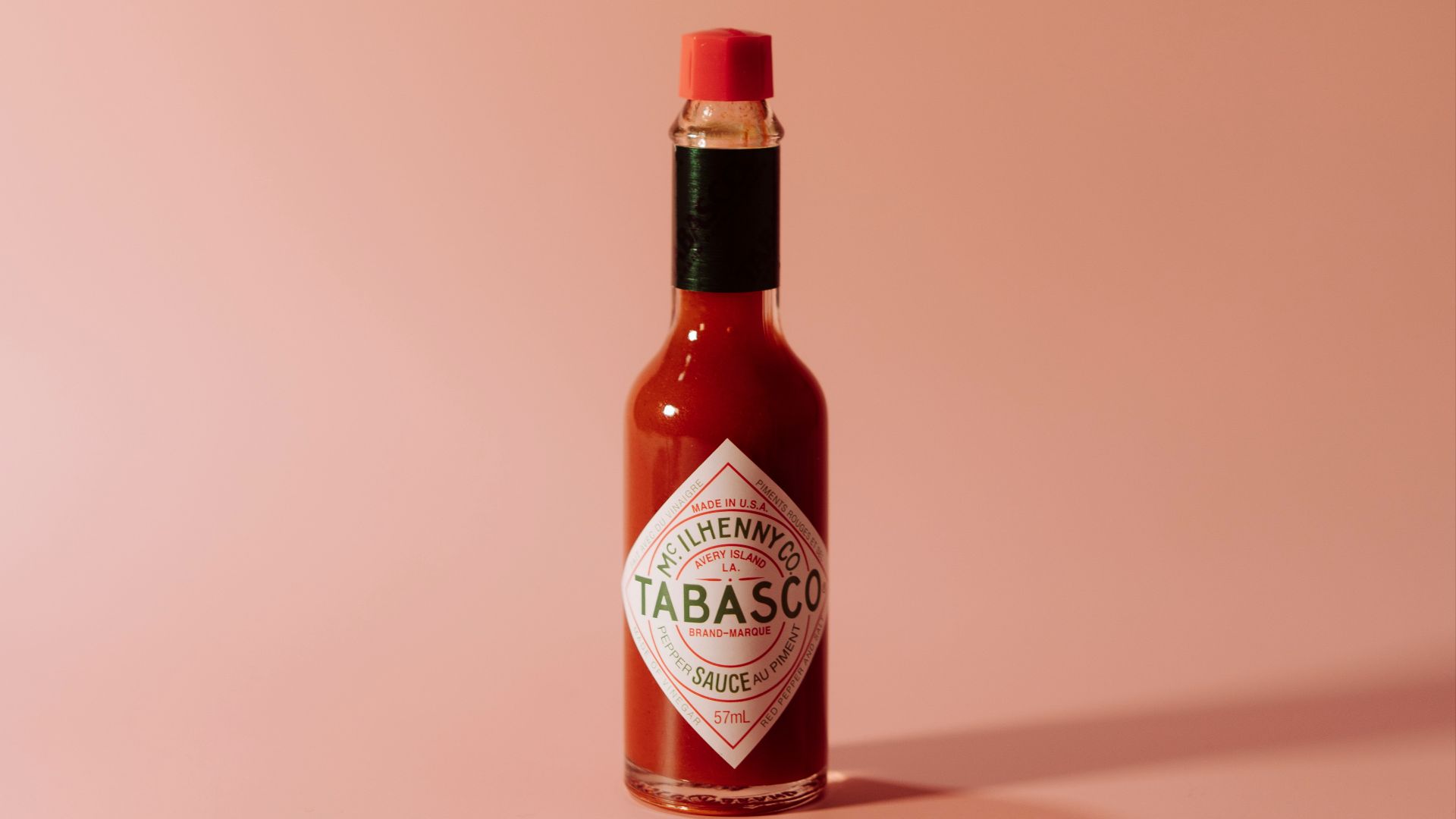a bottle of tabbabata sauce on a pink background