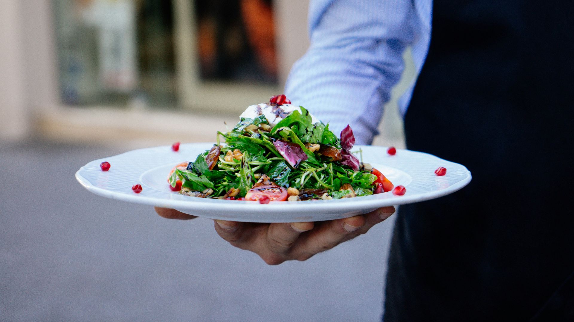 person holding a plate of salad