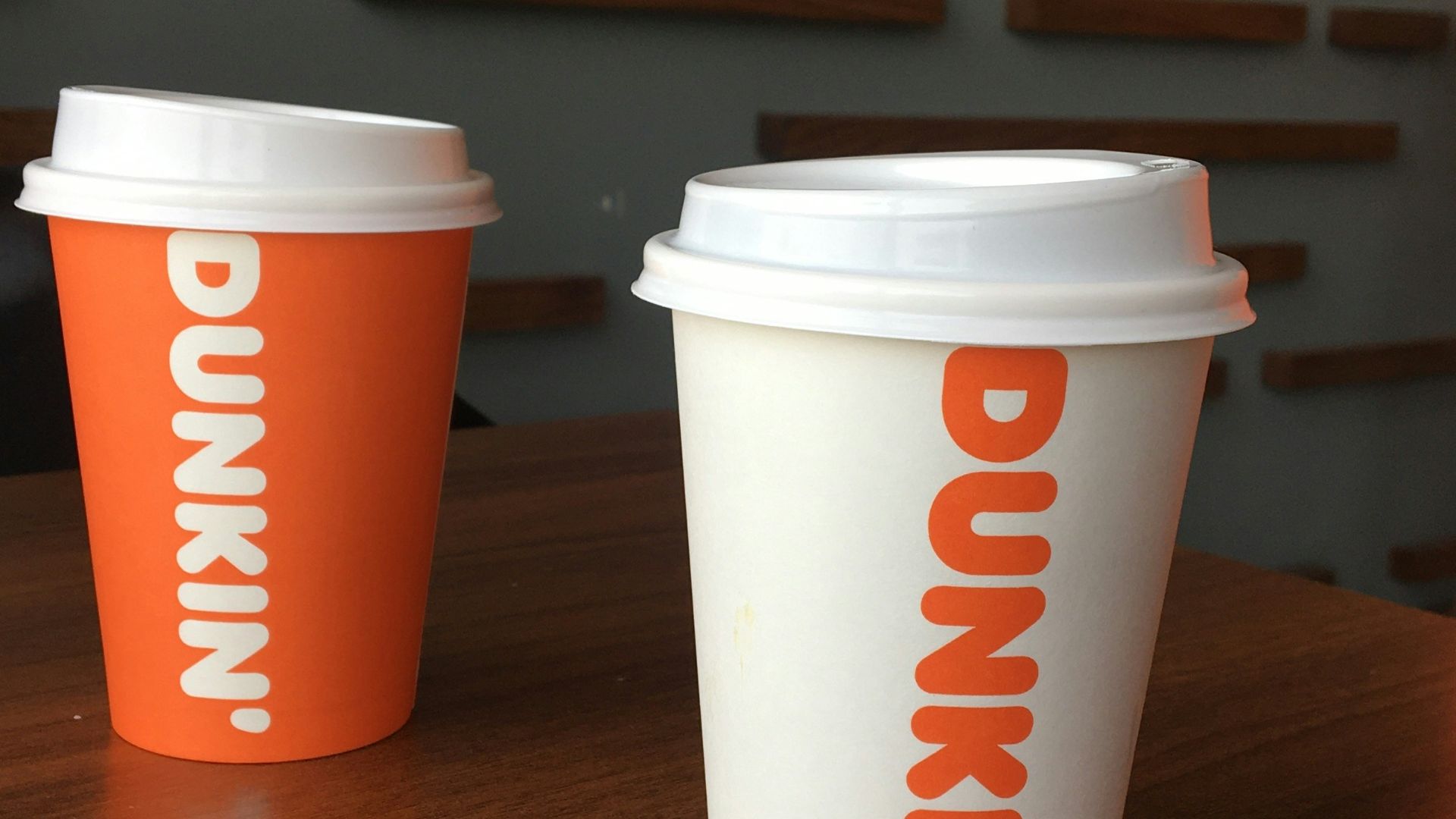 Three coffee cups sitting on top of a wooden table