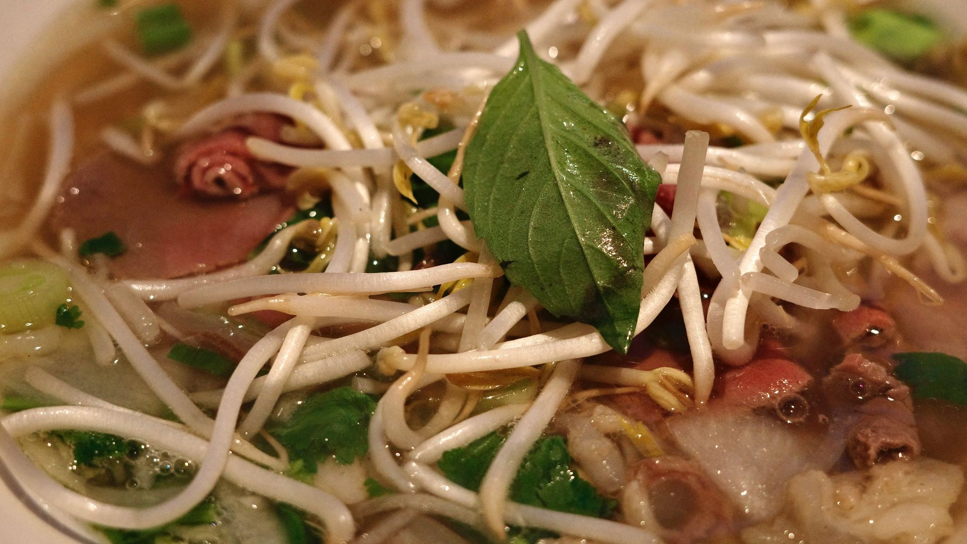 a bowl of soup with noodles, meat and vegetables