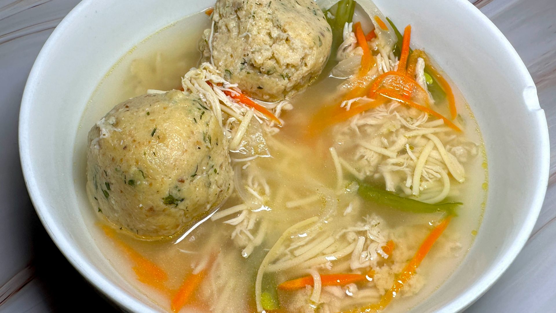 a bowl of soup with meatballs and vegetables