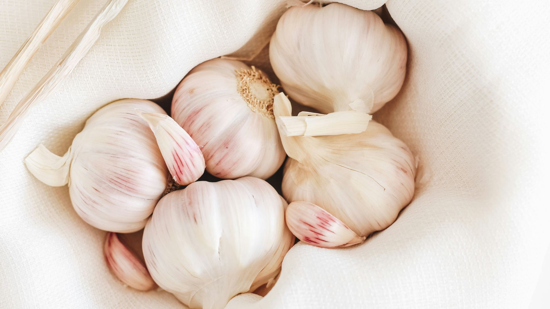 five garlic on white textile