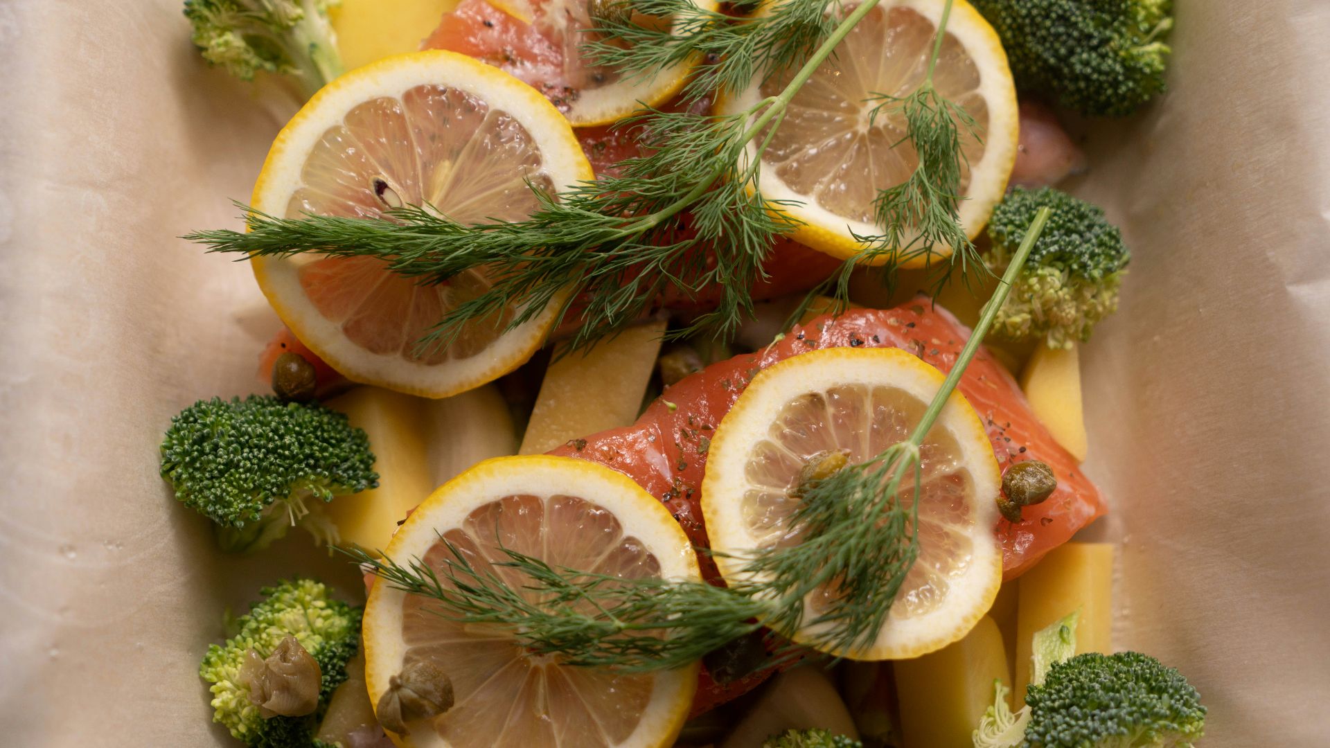 a white bowl filled with sliced up lemons and broccoli