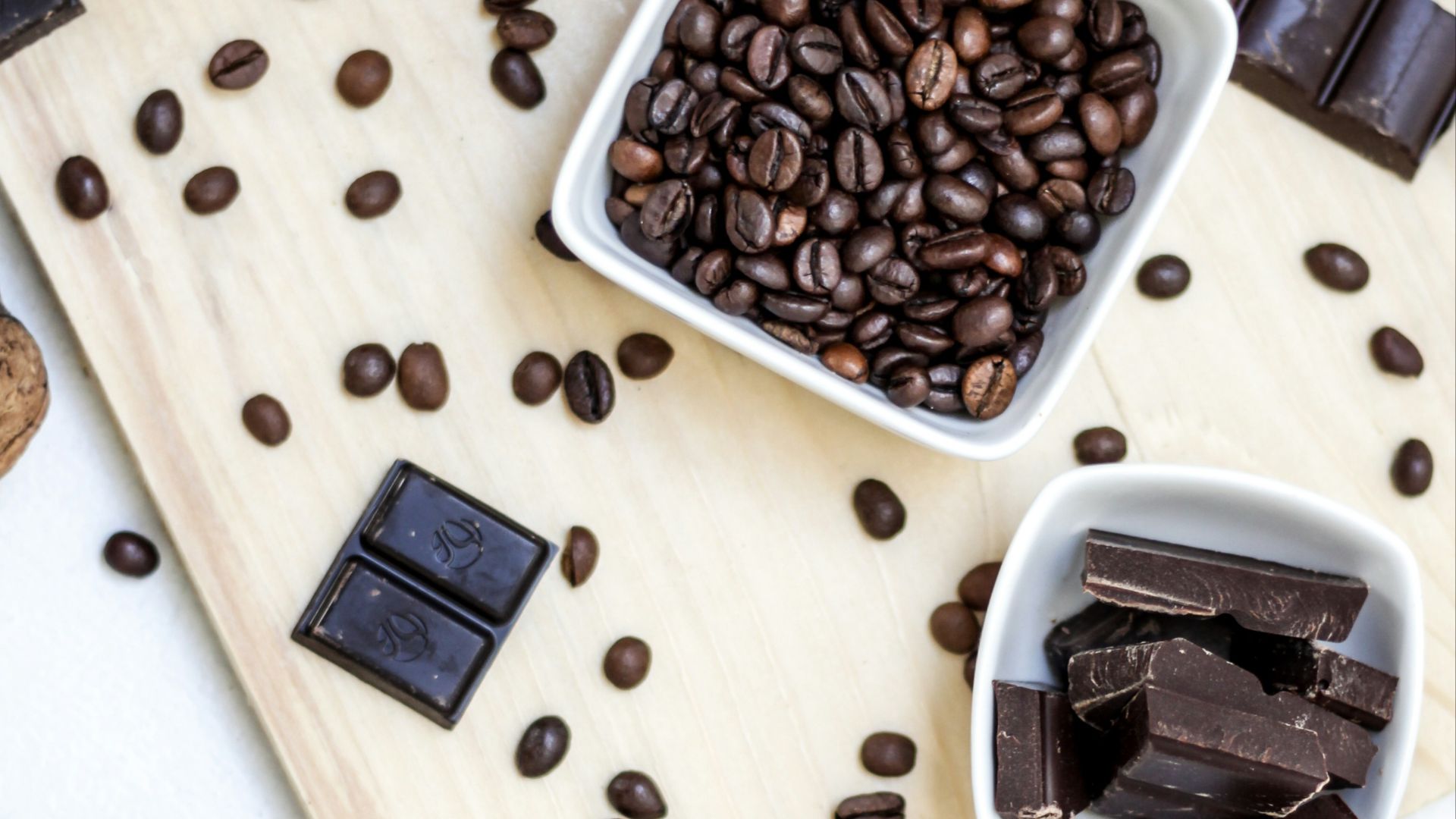 chocolate and coffee seeds on table near bowls