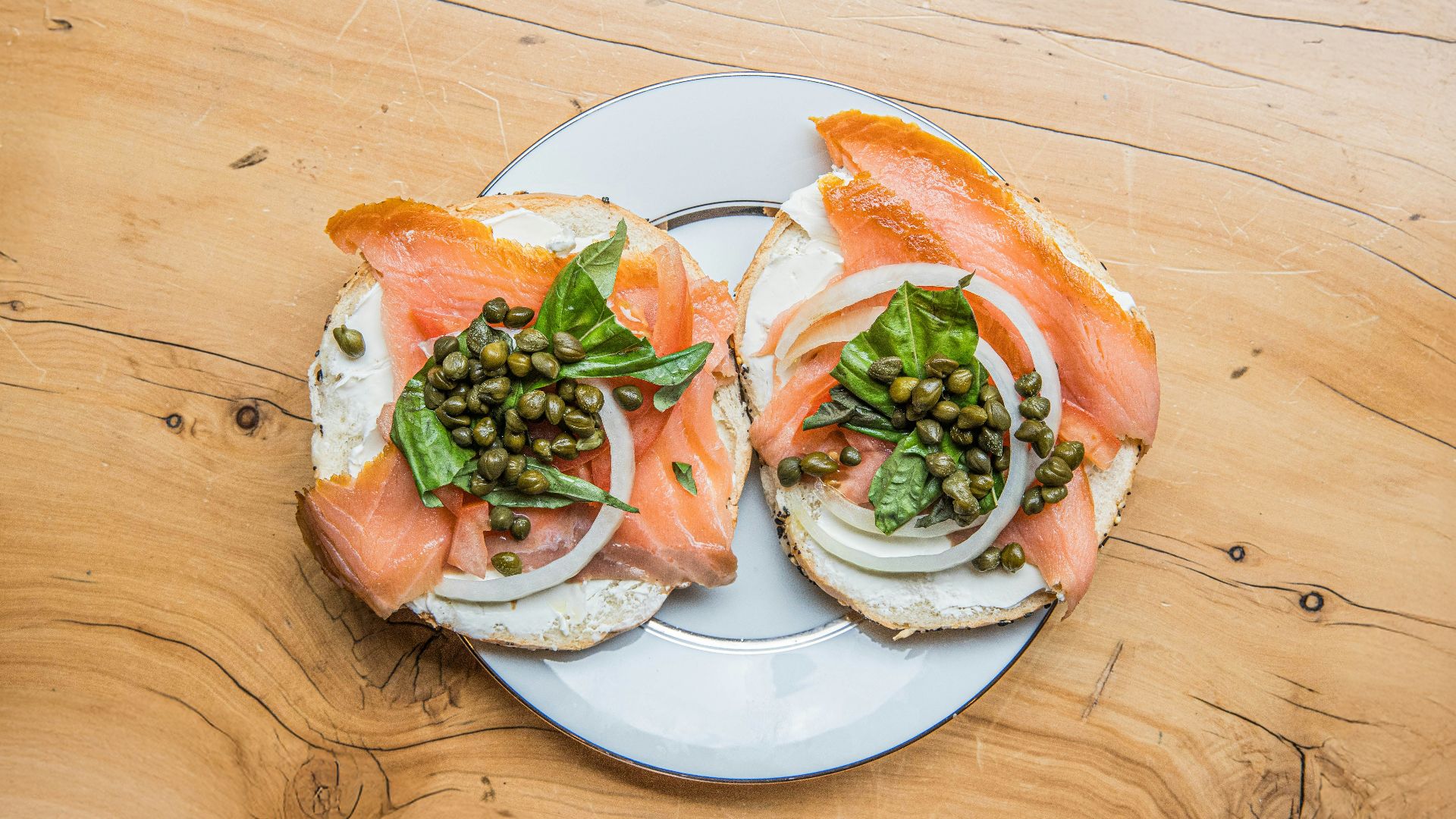A white plate topped with two sandwiches covered in toppings