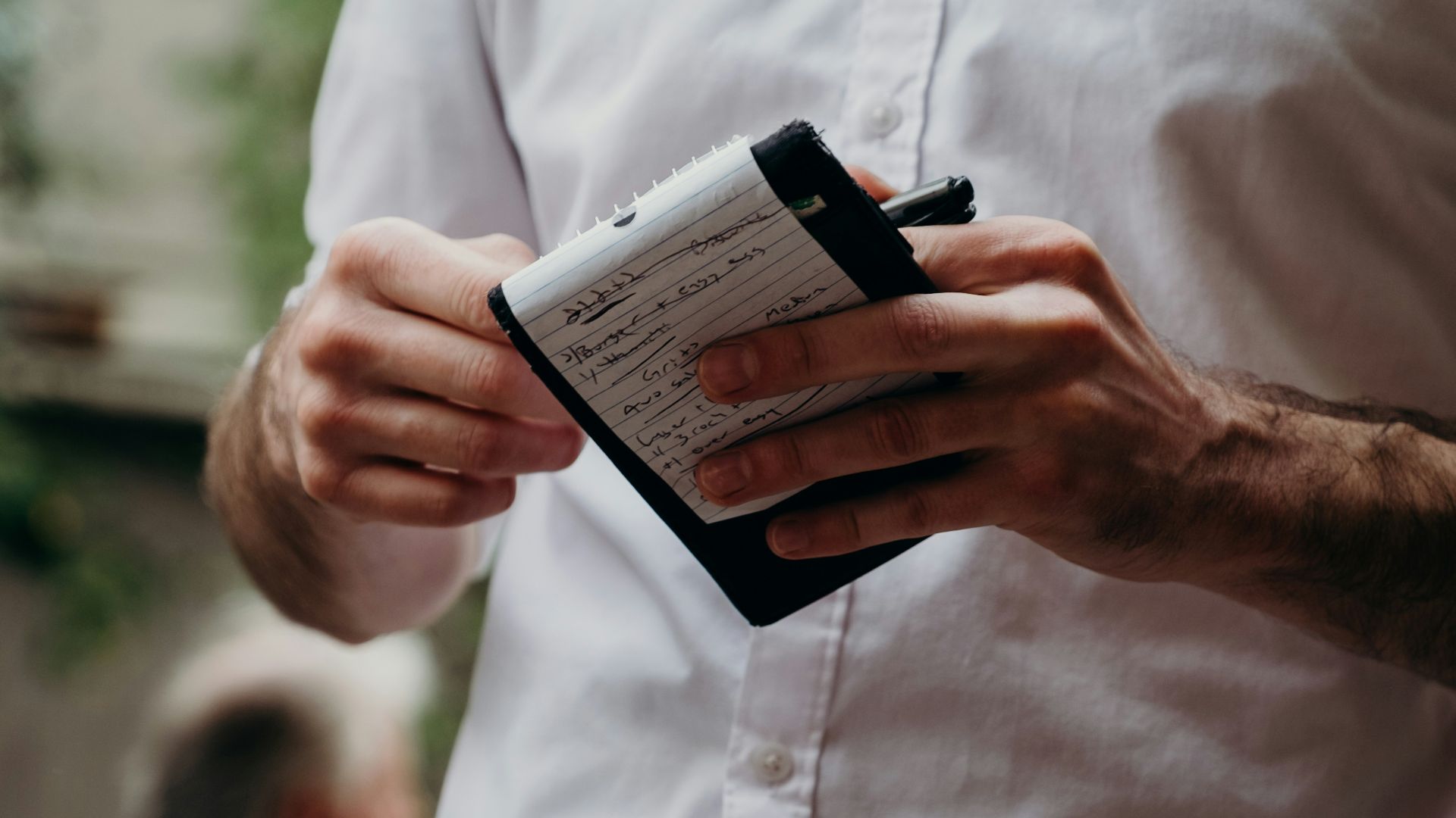man in white button up shirt holding black and white box