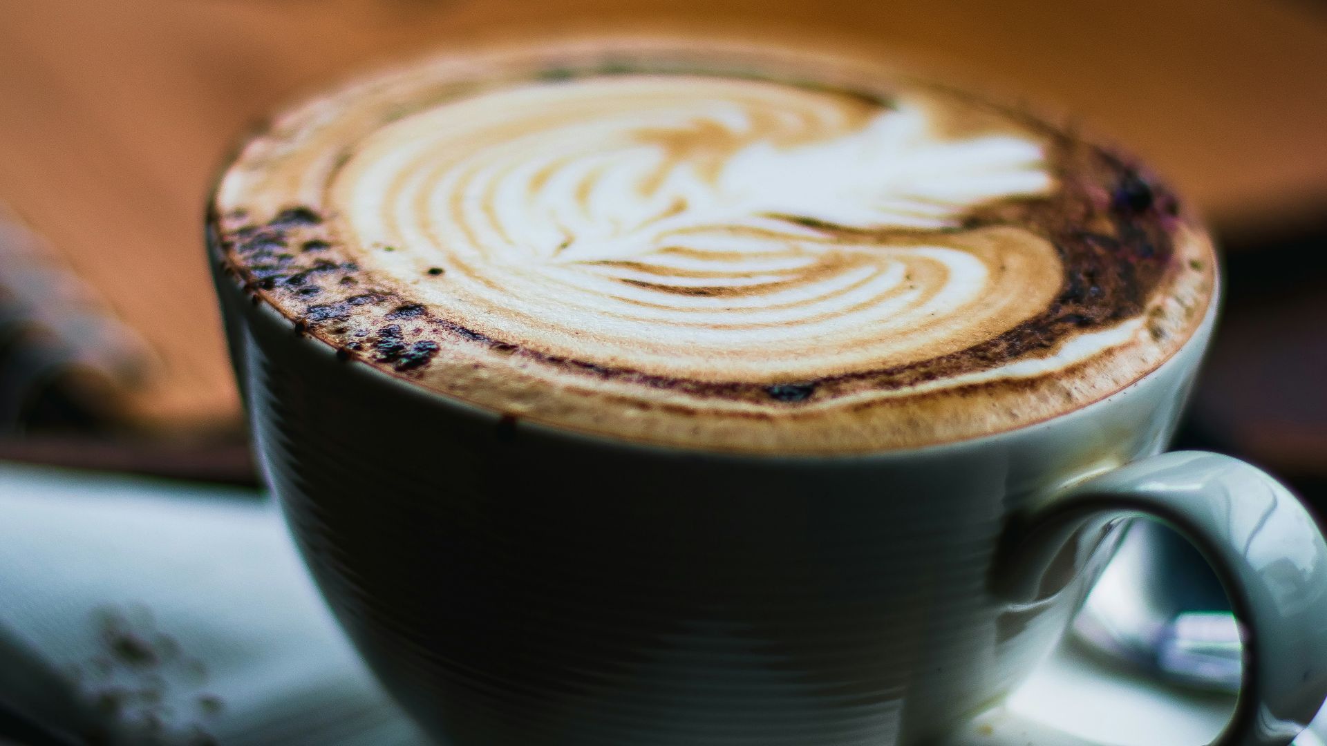 a cappuccino on a saucer with a spoon