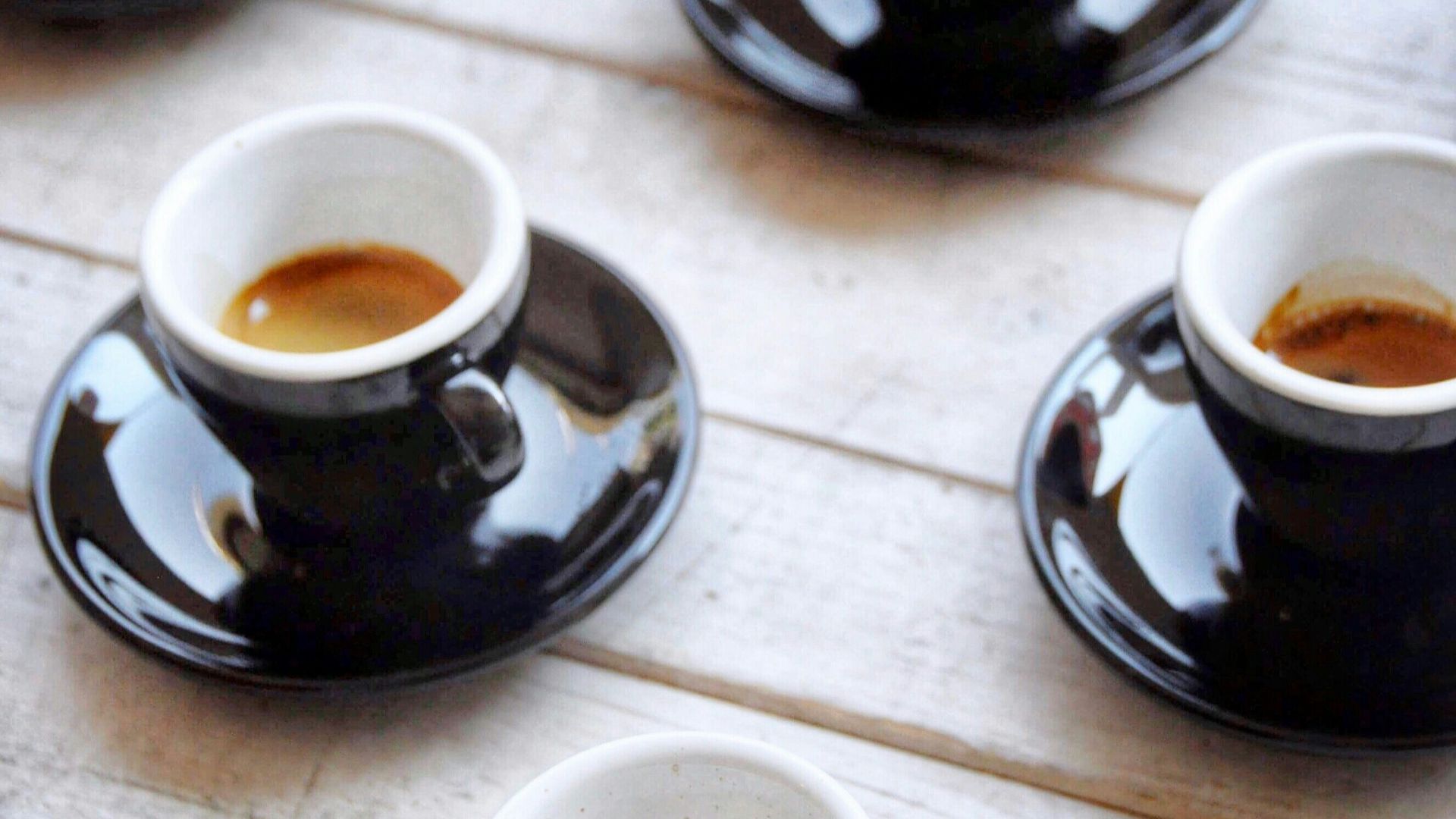 selective focus photography of four black-and-white ceramic cups and saucers