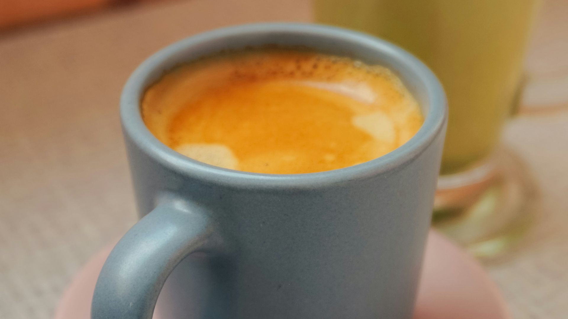 blue ceramic mug with brown liquid inside