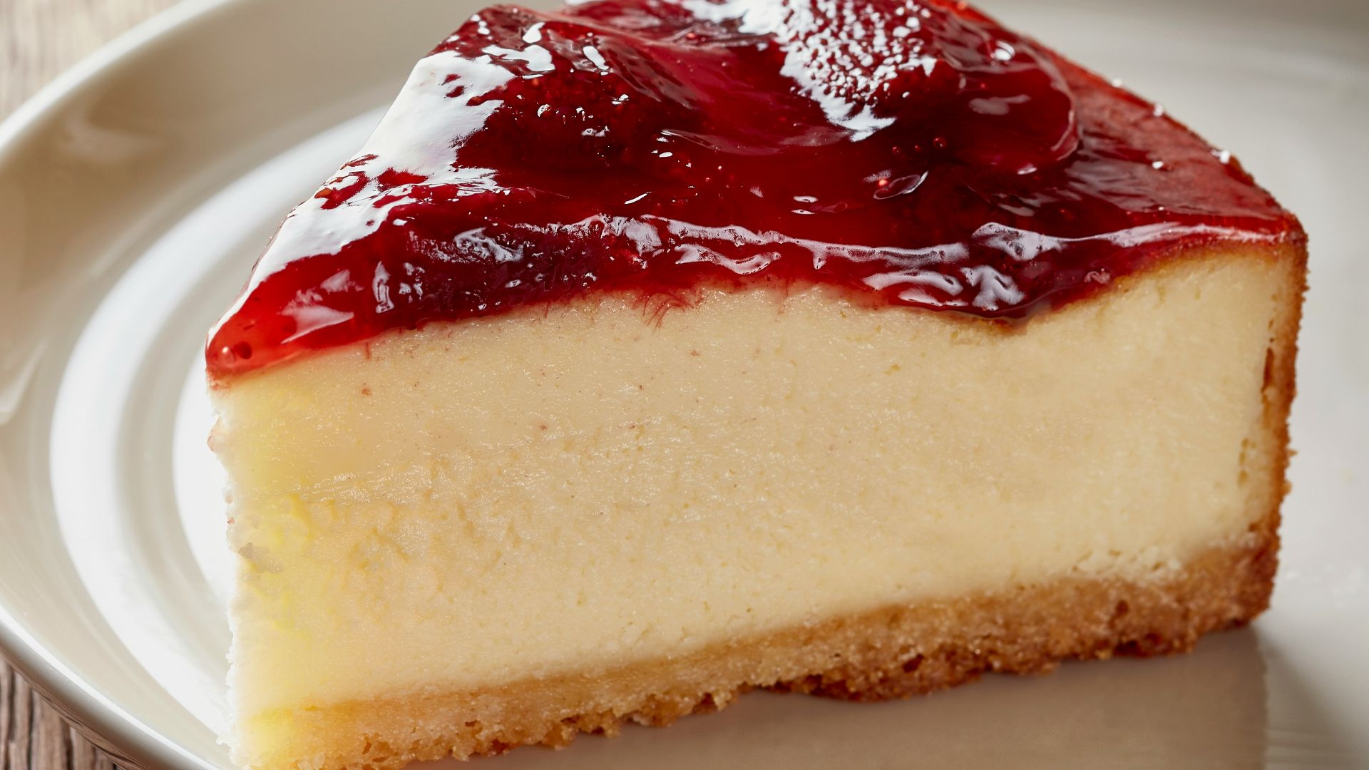 a piece of cheesecake on a plate next to a cup of coffee