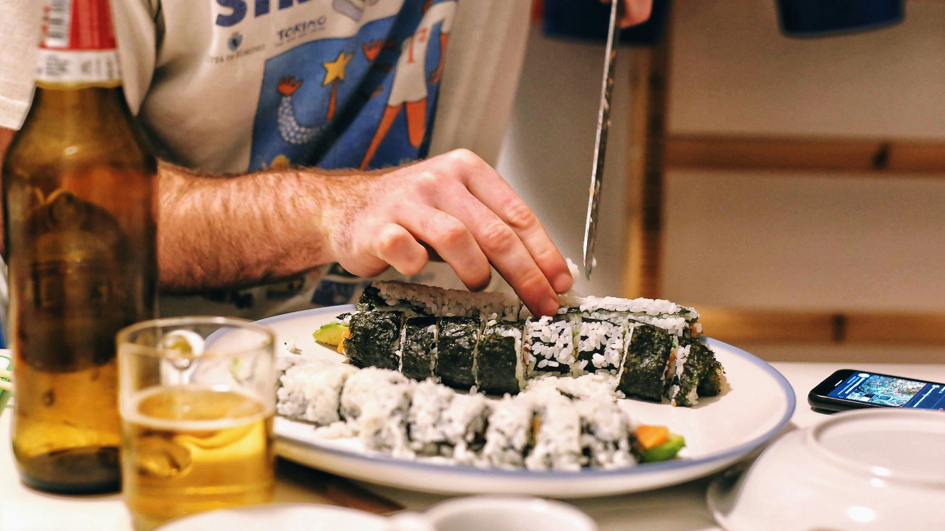 man in gray and blue crew neck t-shirt slicing chocolate cake on white ceramic plate