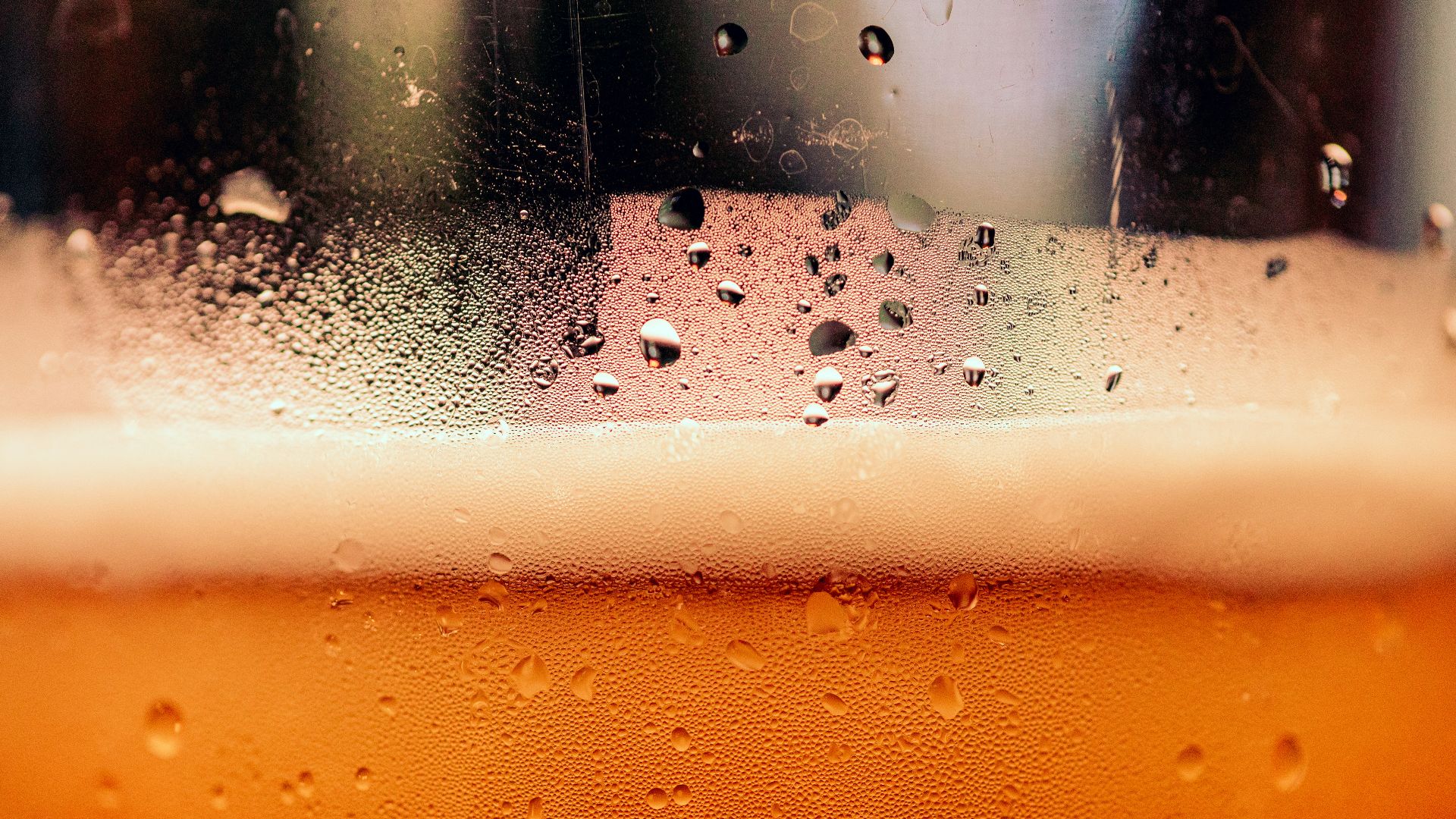 a close up of a glass of beer with drops of water
