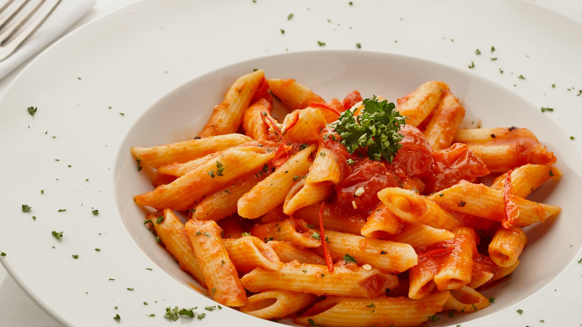 a white plate topped with pasta covered in sauce