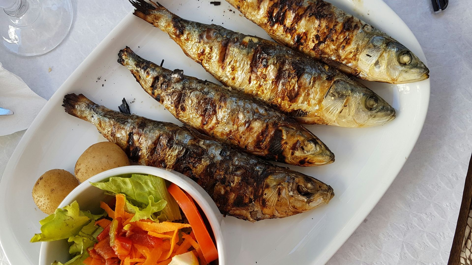grilled fish with vegetable salad on white ceramic plate