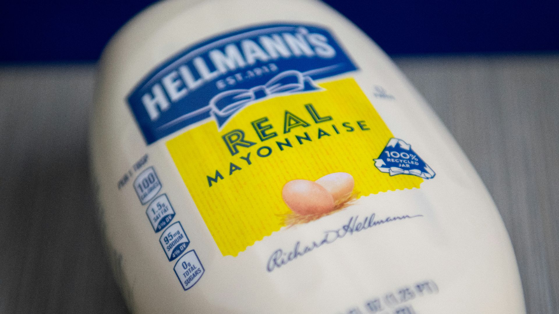 a hand holding a white container