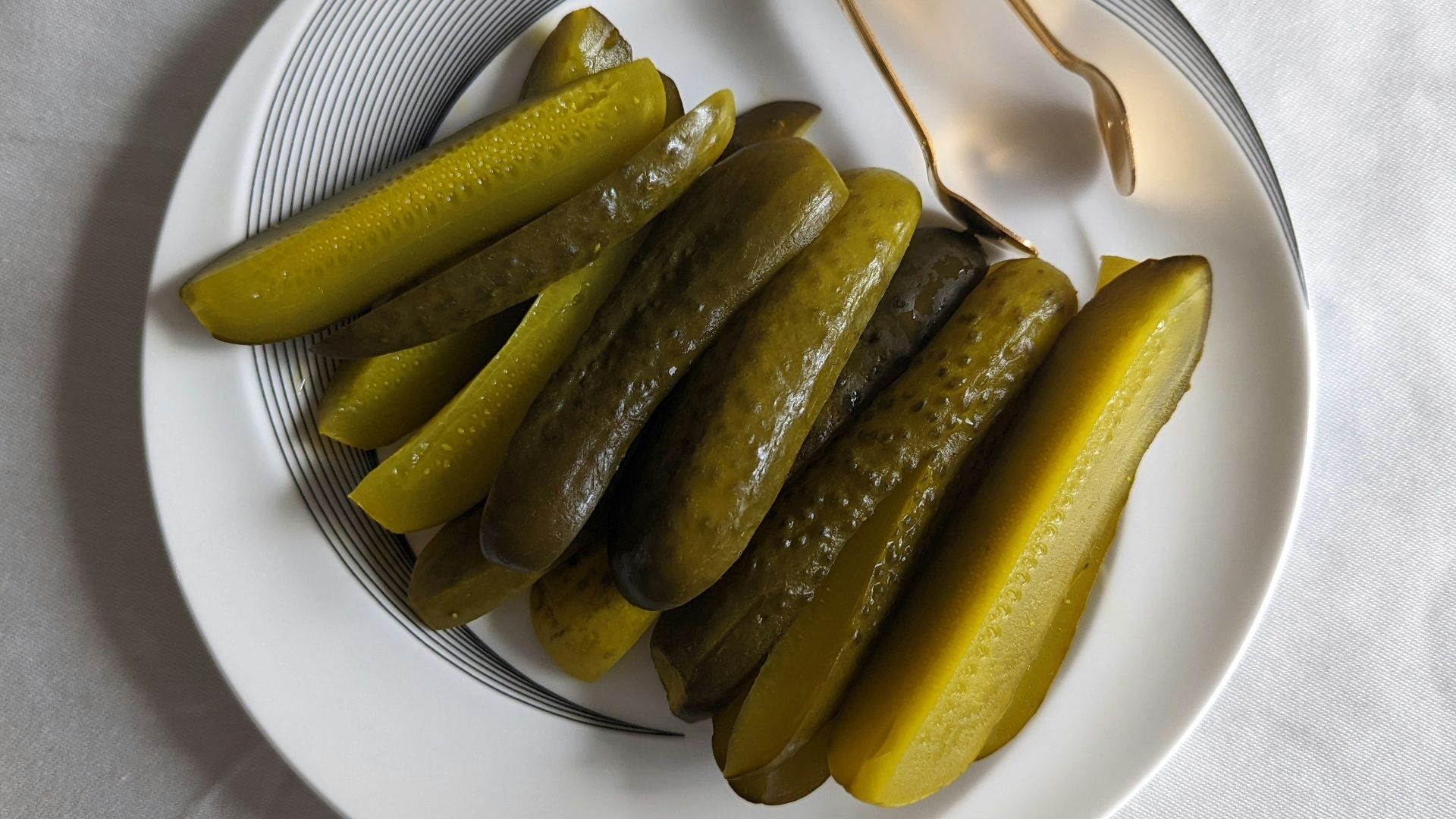 a white plate topped with pickles next to a fork
