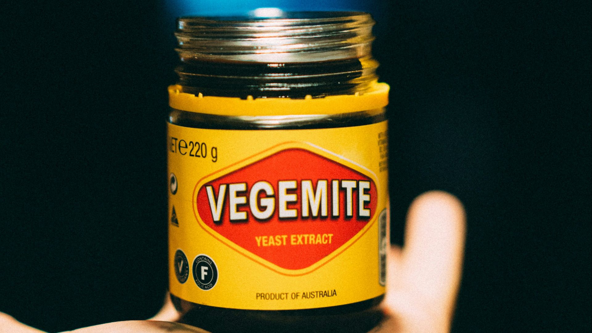 person holding yellow and black bottle