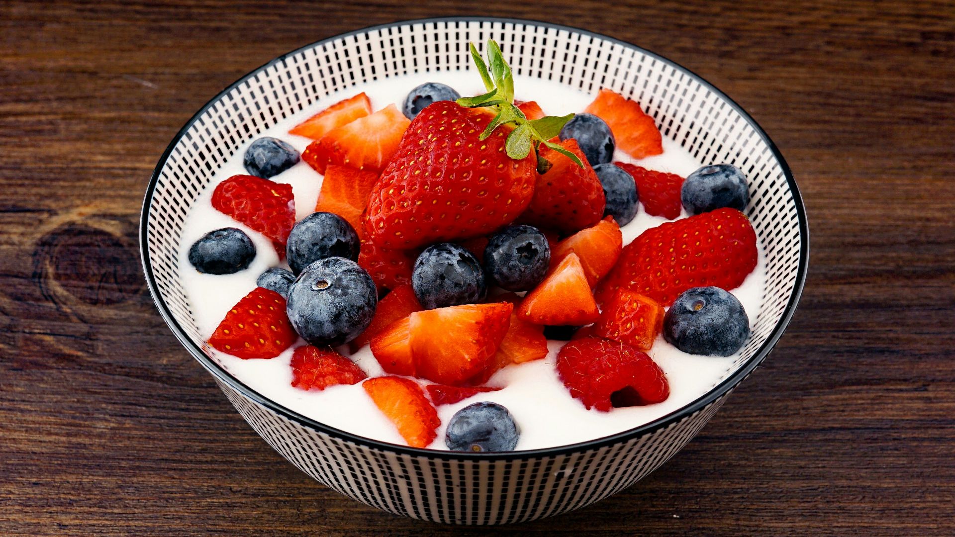 strawberry and blackberries on top of brown table