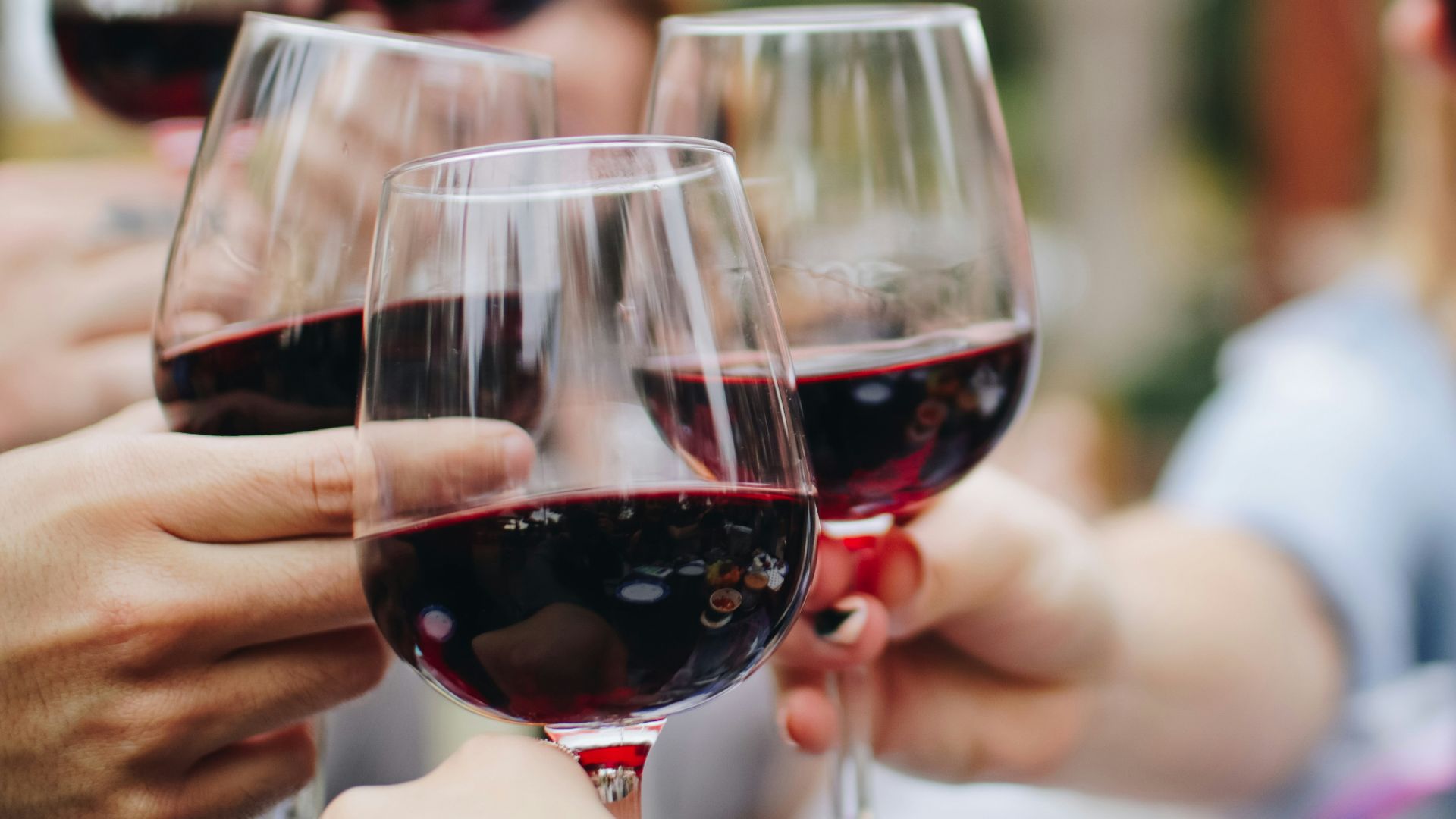 people tossing their clear wine glasses