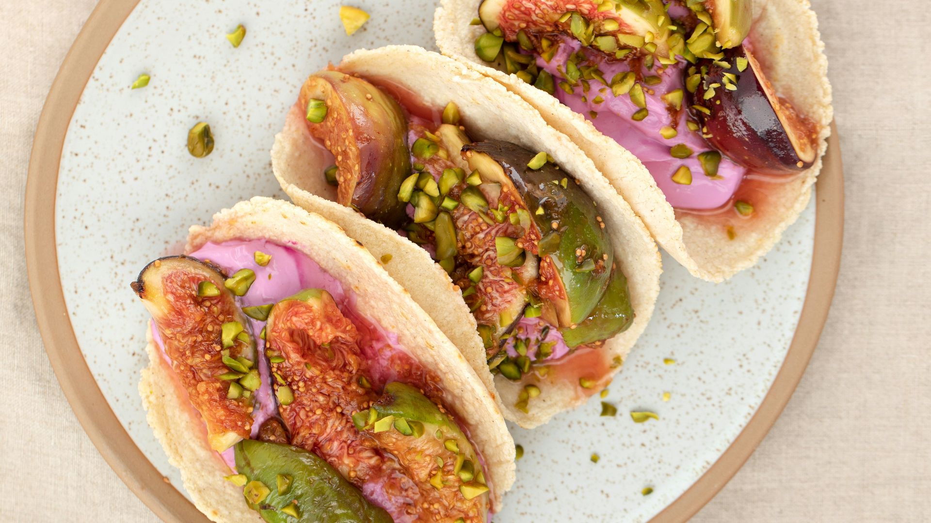 three tacos on a plate on a table