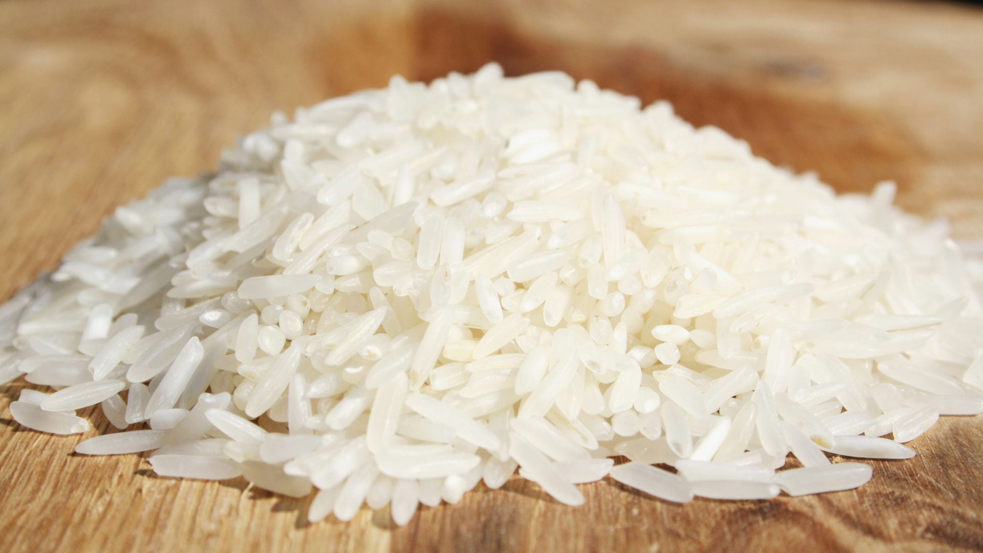 A pile of rice sitting on top of a wooden cutting board