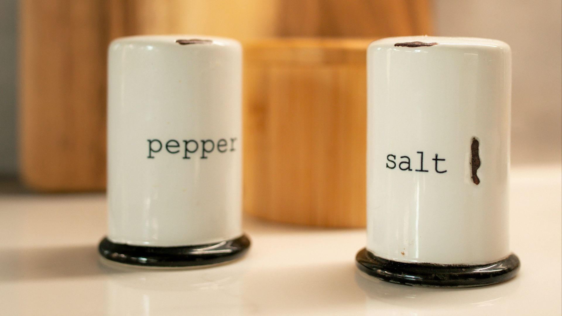 two salt and pepper shakers sitting on a counter