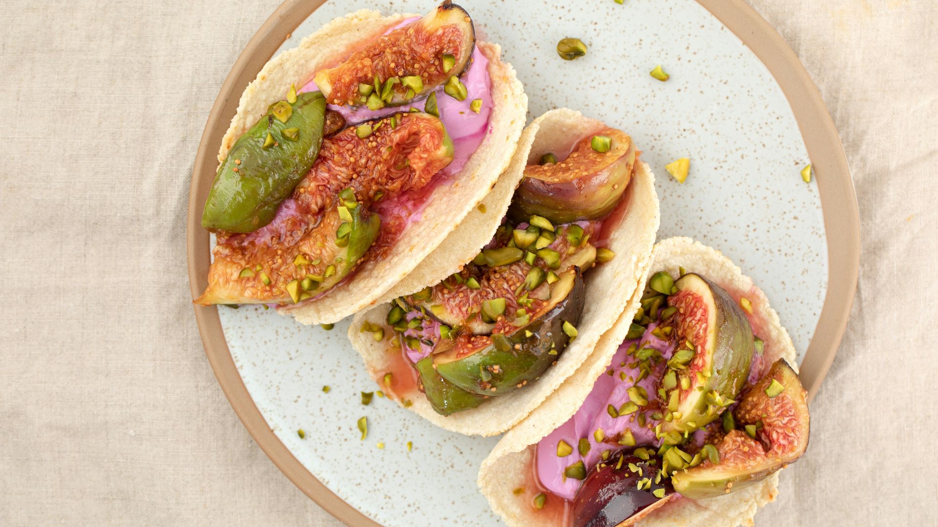 three tacos on a plate on a table